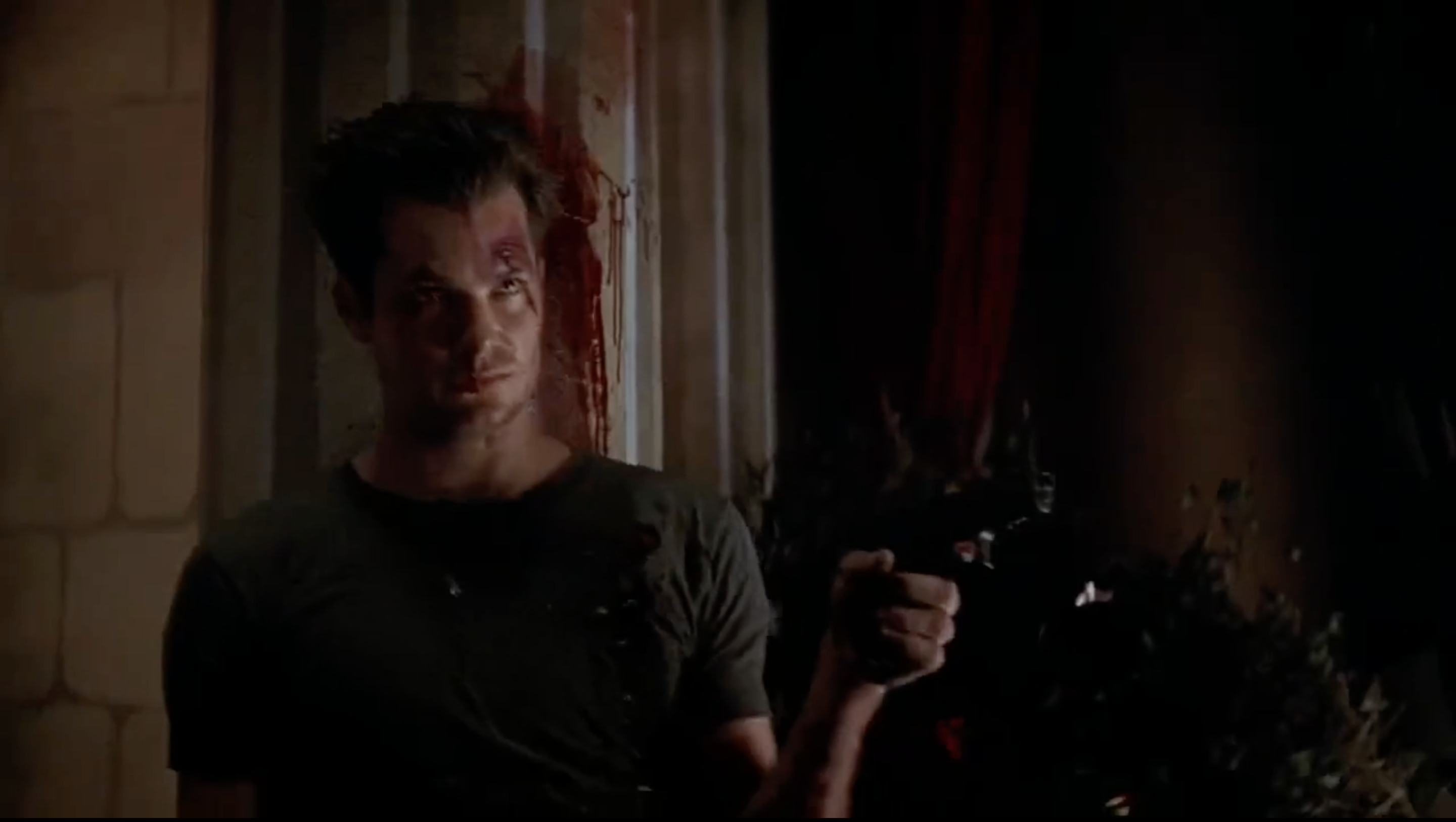 Timothy Olyphant bleeds against a pillar with a gun in his hand