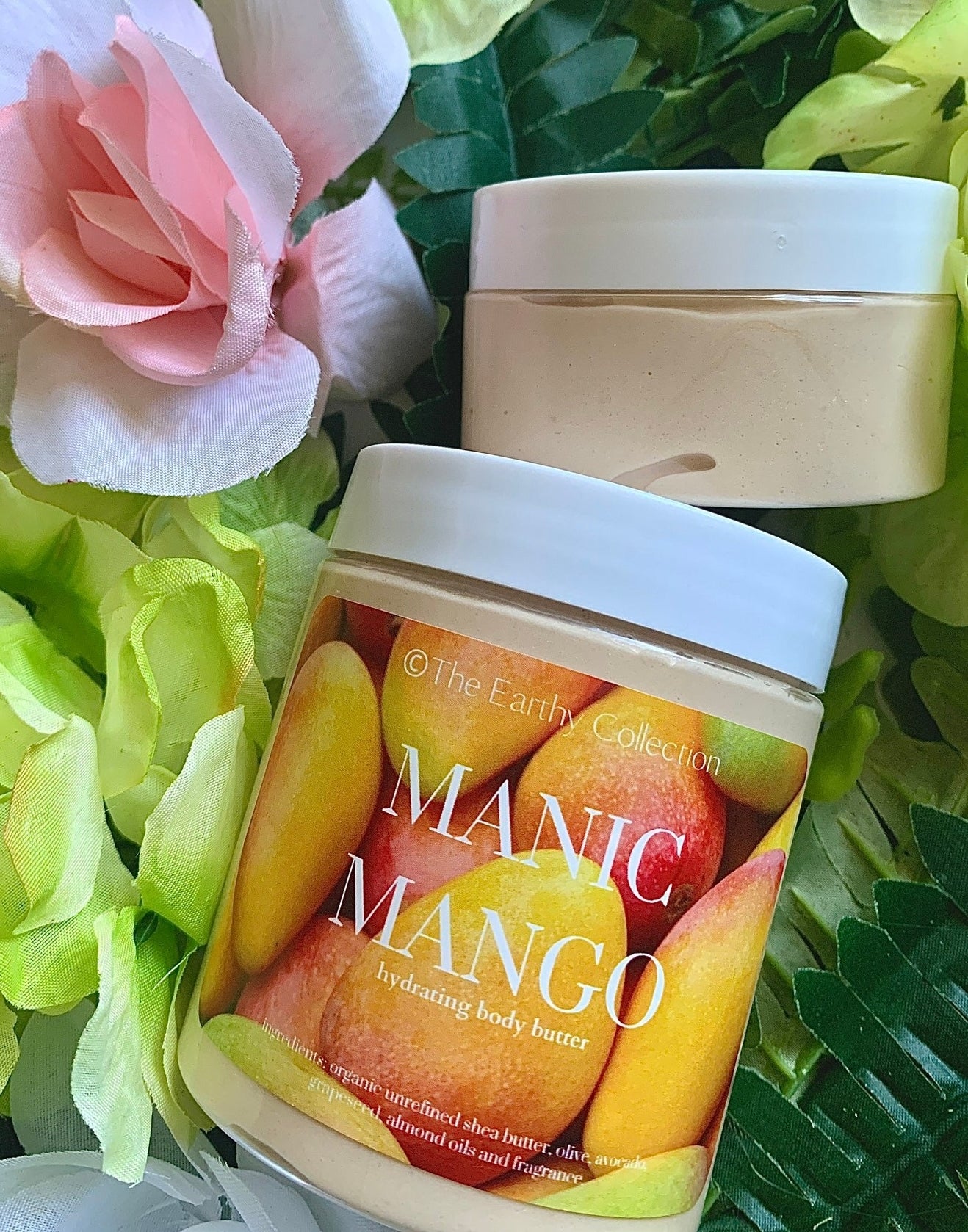 Two jars of orange body butter with photo of mangos on label