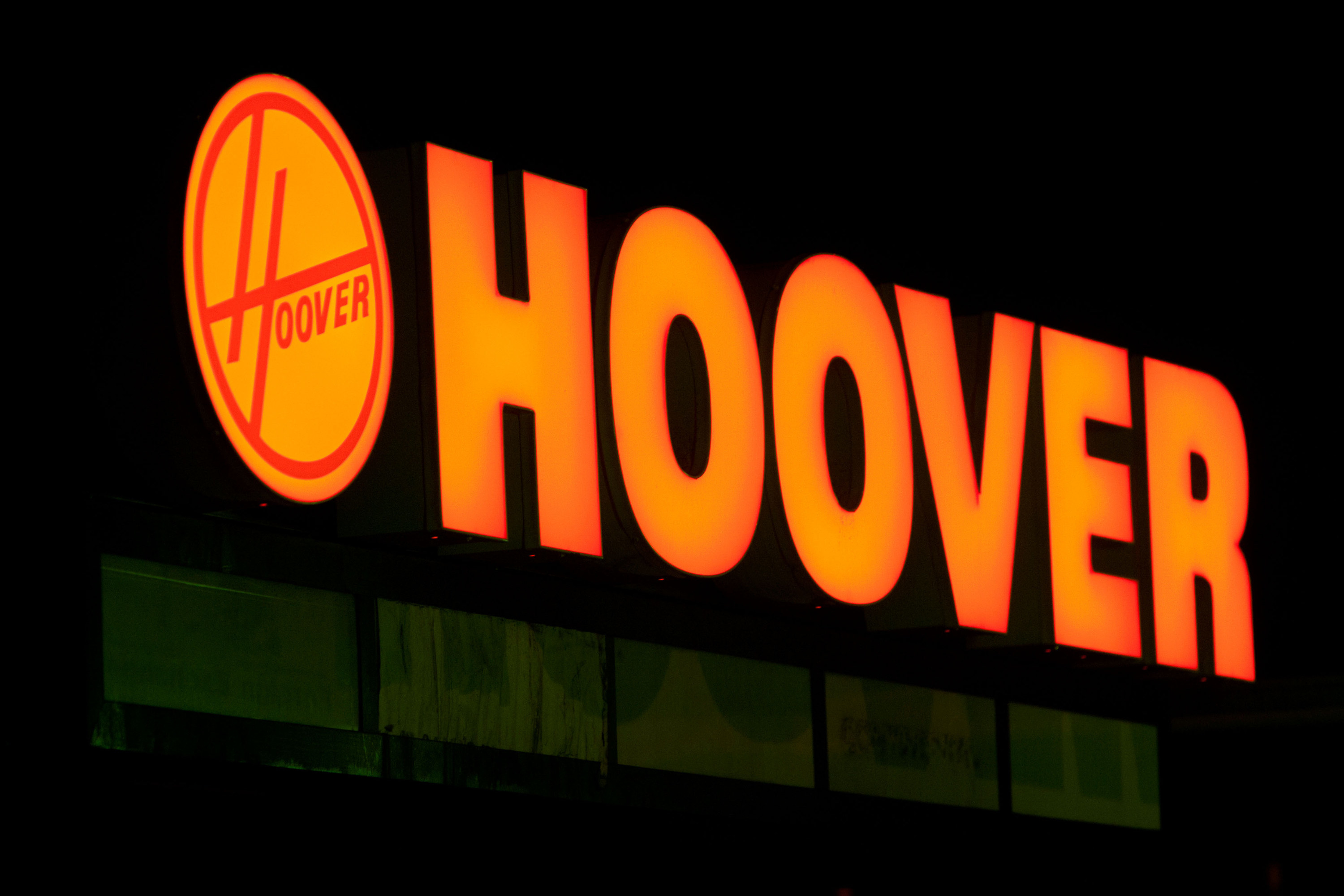 A Hoover sign on a storefront at night