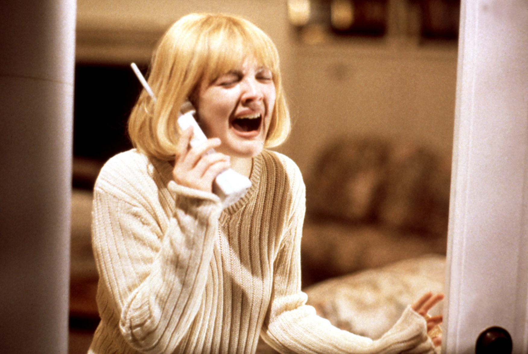 Drew Barrymore in a blonde bob wig, holding an old house telephone screaming