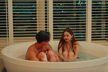 Ji-a smiles at Hyun-seung as they sit in a small jacuzzi