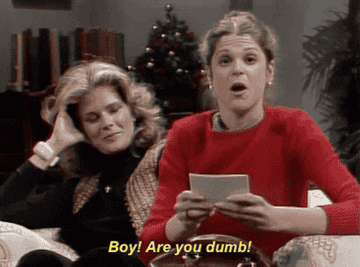 Gilda Radner sits next to Candice Bergen on a couch as she holds a stack of paper and says &quot;Boy! Are you dumb!&quot; in &quot;Saturday Night Live&quot;