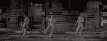 Men in gray suits dancing in the street