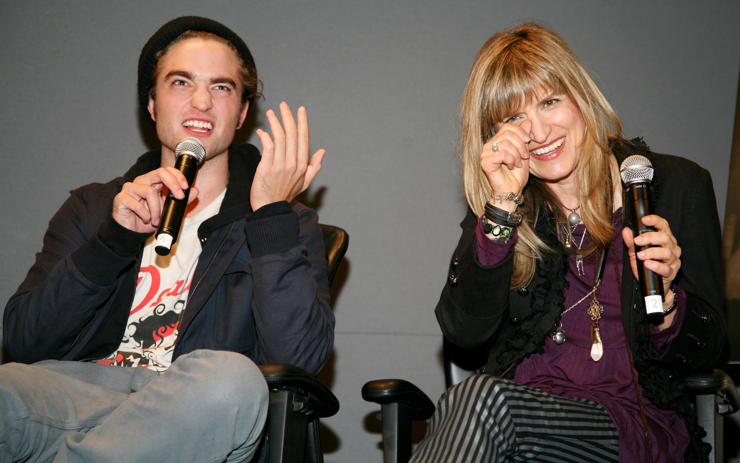 Catherine and Robert laugh on stage during an event