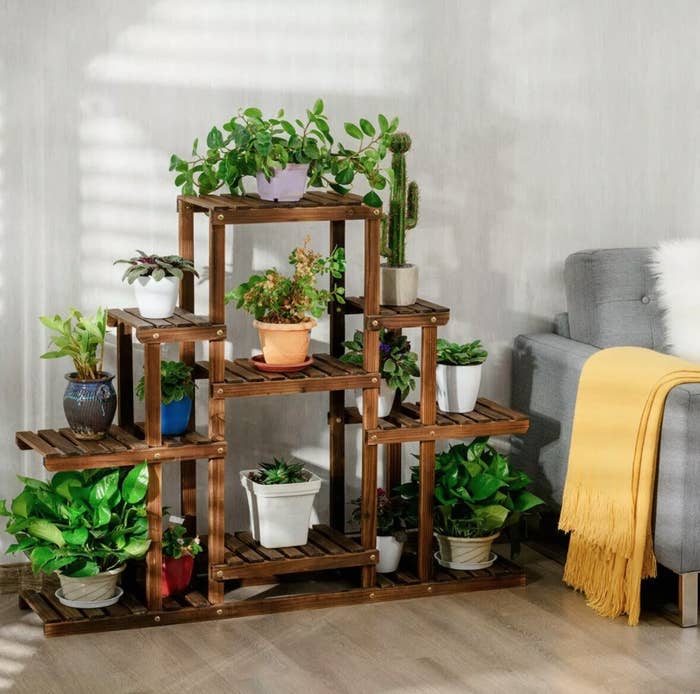 the wooden plant stand next to a couch
