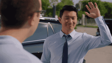 Man waving and another mistakenly high-fiving him