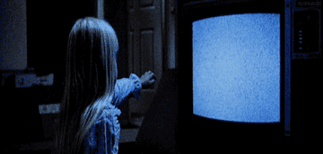 Ghostly hand reaching out of a television