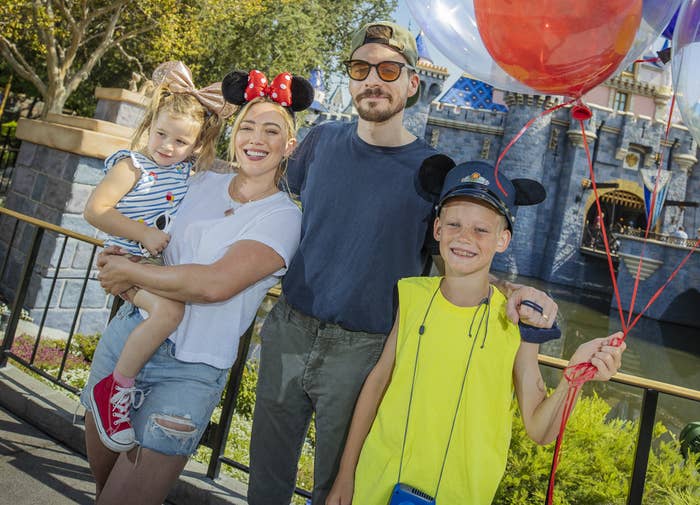 Hilary holds Banks while at Disneyland with her husband and son
