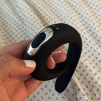 Reviewer holding cock ring to display adjustable buckle