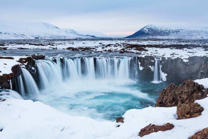 Snow surrounding a waterfall