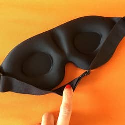 a reviewer showing the back side of the eye mask