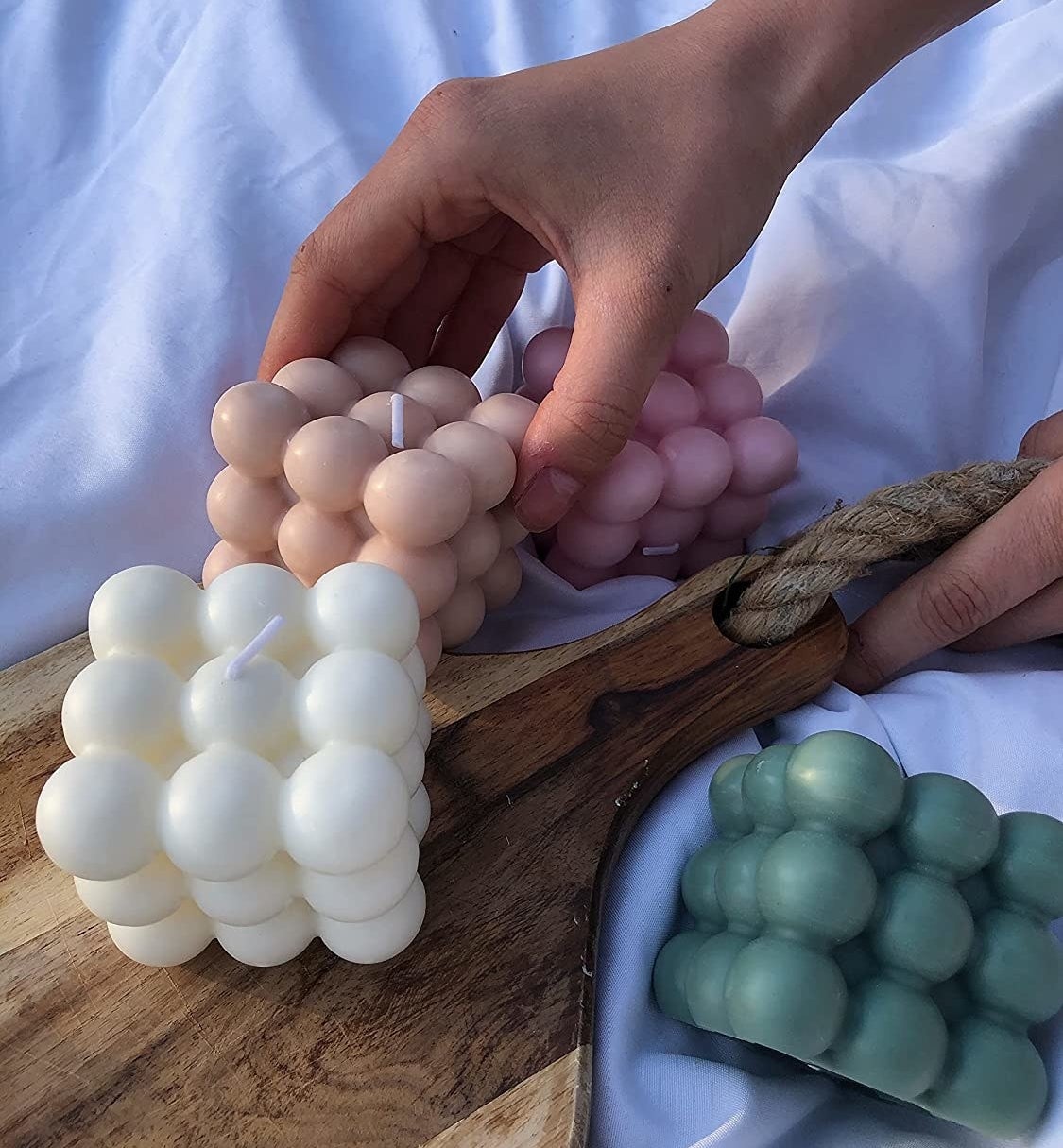 Four bubble candles surrounding and on top of a wooden board