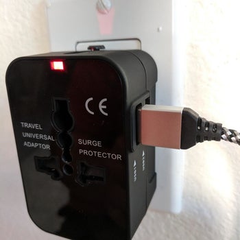 a reviewer photo of the adaptor plugged into a wall outlet with a USB cord plugged into the adaptor