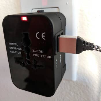 a reviewer photo of the adaptor plugged into a wall outlet with a USB cord plugged into the adaptor