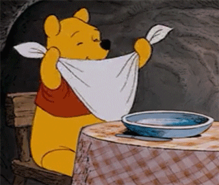 Winnie the pooh sitting down excited to eat