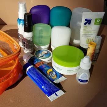 a reviewer photo of lots of toiletries sitting next to an orange bag with a transparent front