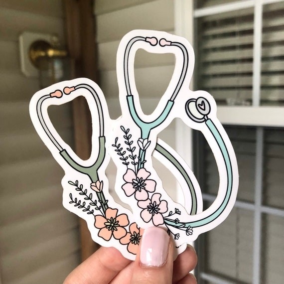 person holding two floral stethoscope stickers