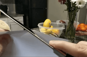 GIF of reviewer slicing a piece of paper with the knife to demonstrate how sharp it is