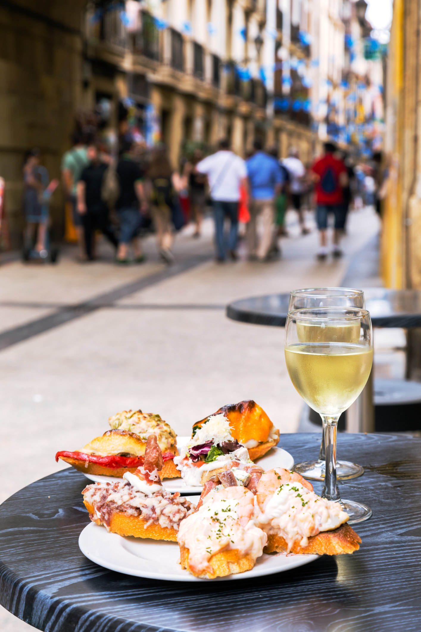 Tapas and wine on a busy street