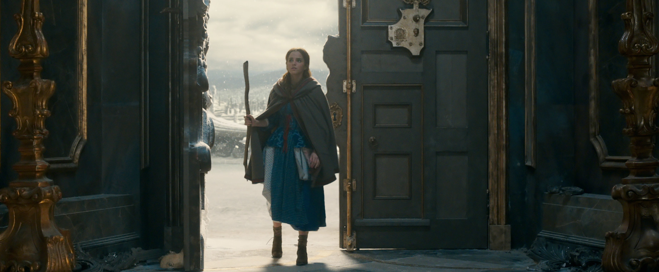 Belle wearing boots and a traveling cloak