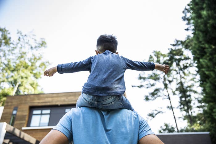 A young boy rides on his parent&#x27;s back