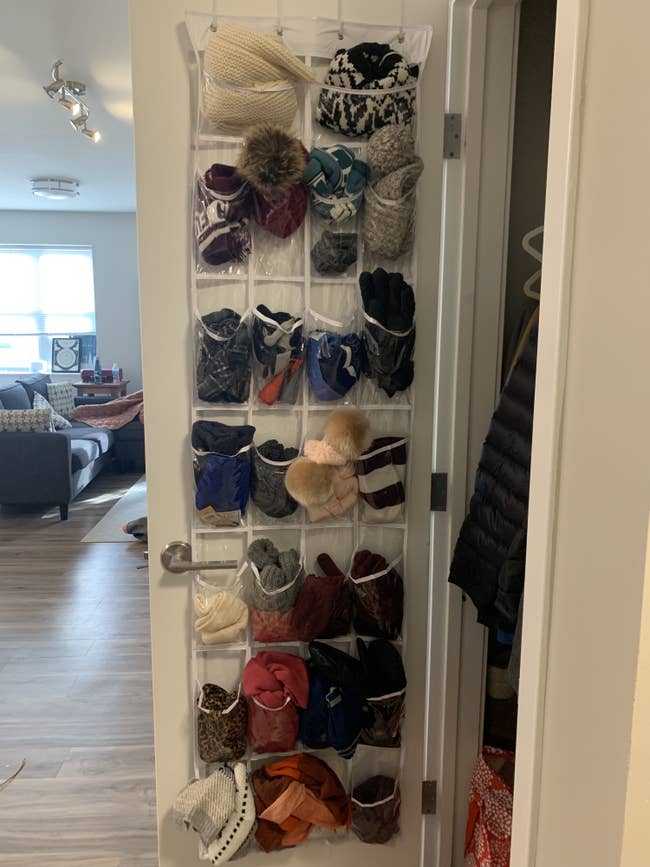 writer's clear organizer holding lots of scarves, gloves, and winter hats