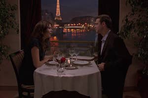 lorelai and chris from gilmore girls eating dinner in front of the eiffel tower 