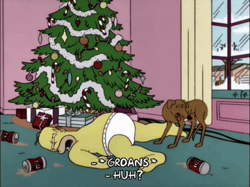 Homer from The Simpsons waking up half naked on the floor next to a Christmas tree and dog