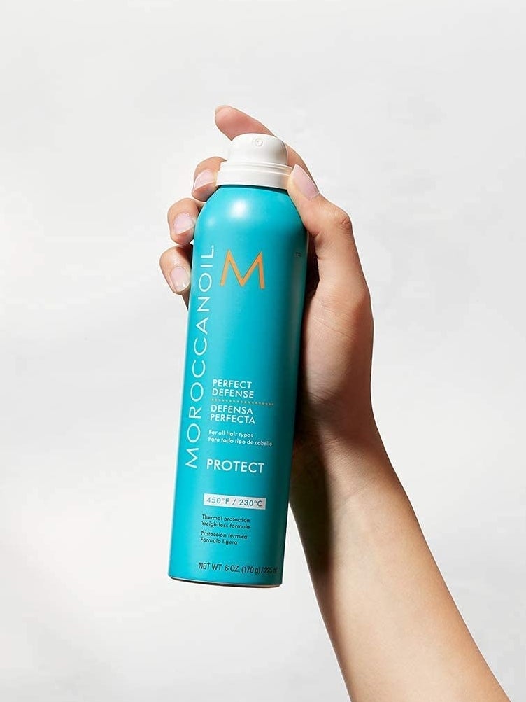 Hand holding a bottle of the heat protectant