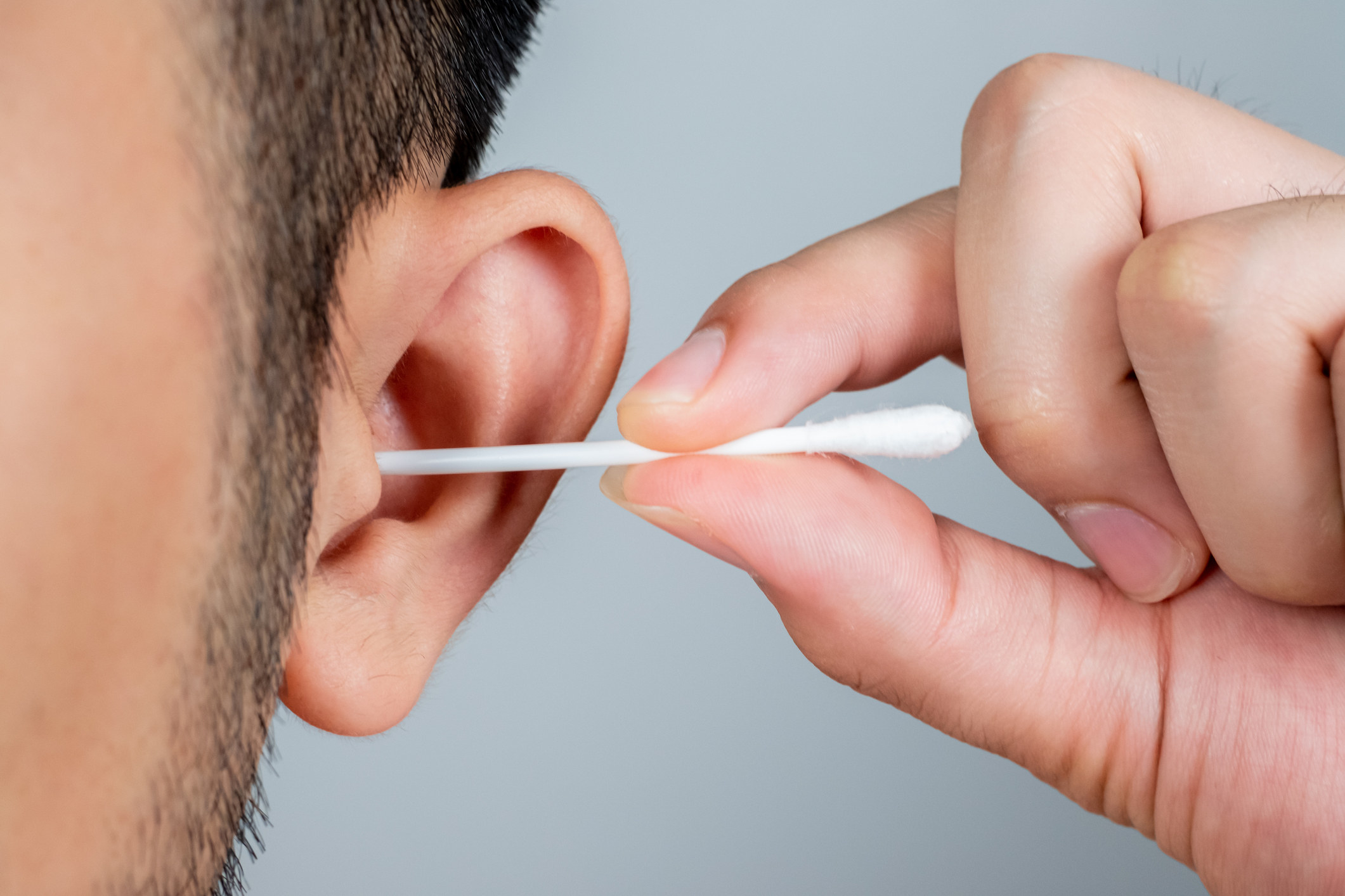 A guy sticking a Q-tip in his ear