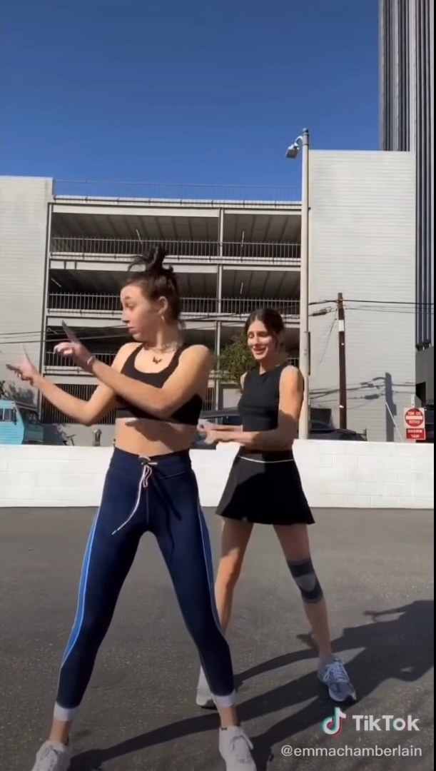 Emma dancing with a friend in a parking garage