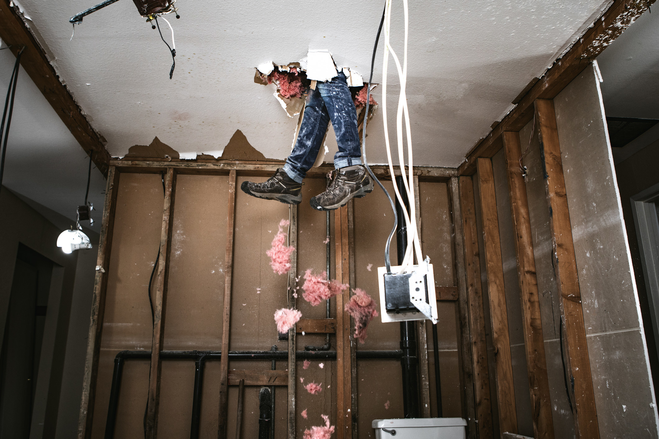 Person falling through the ceiling while renovating a home