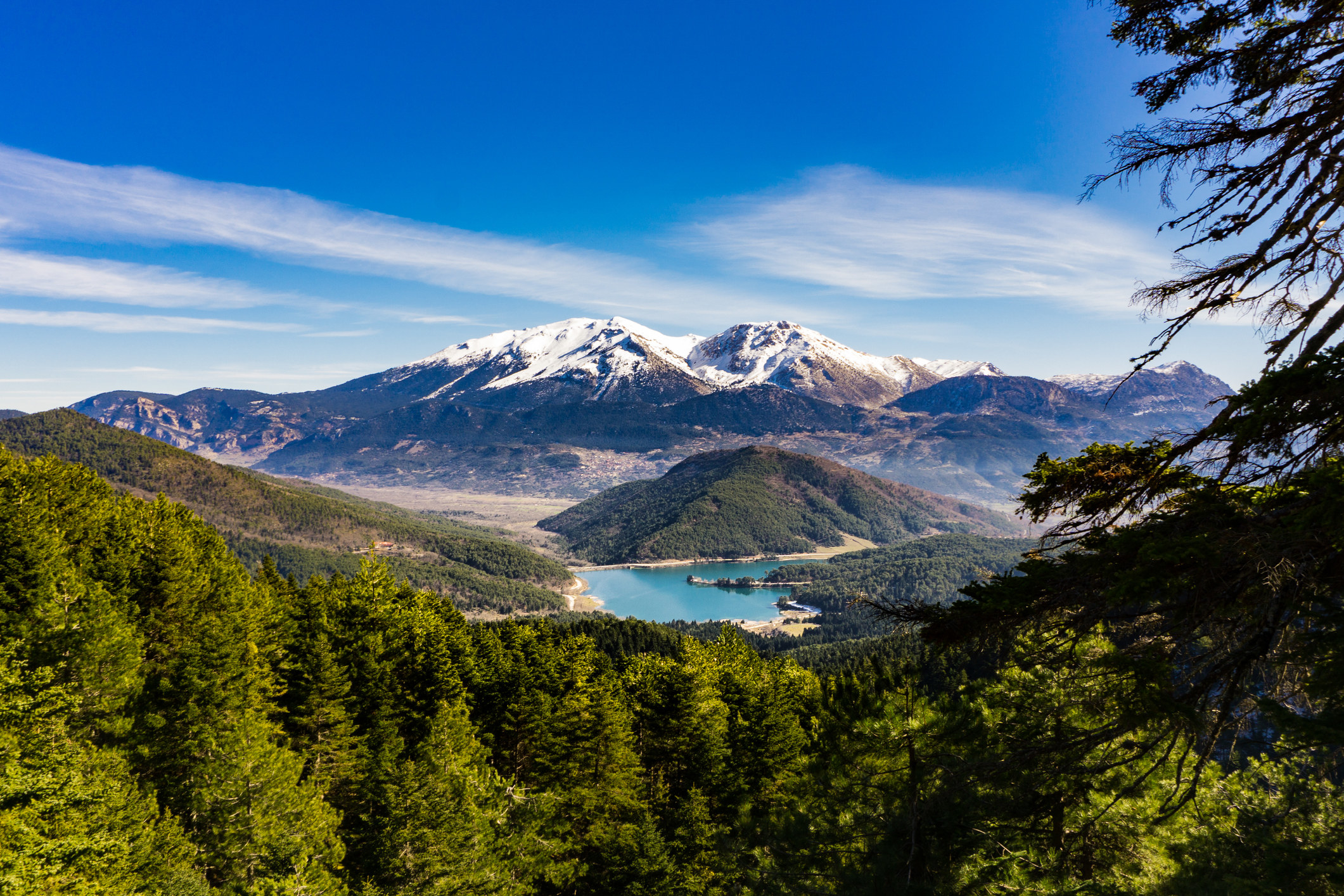 Snow-capped mountains, forests, and a lake.