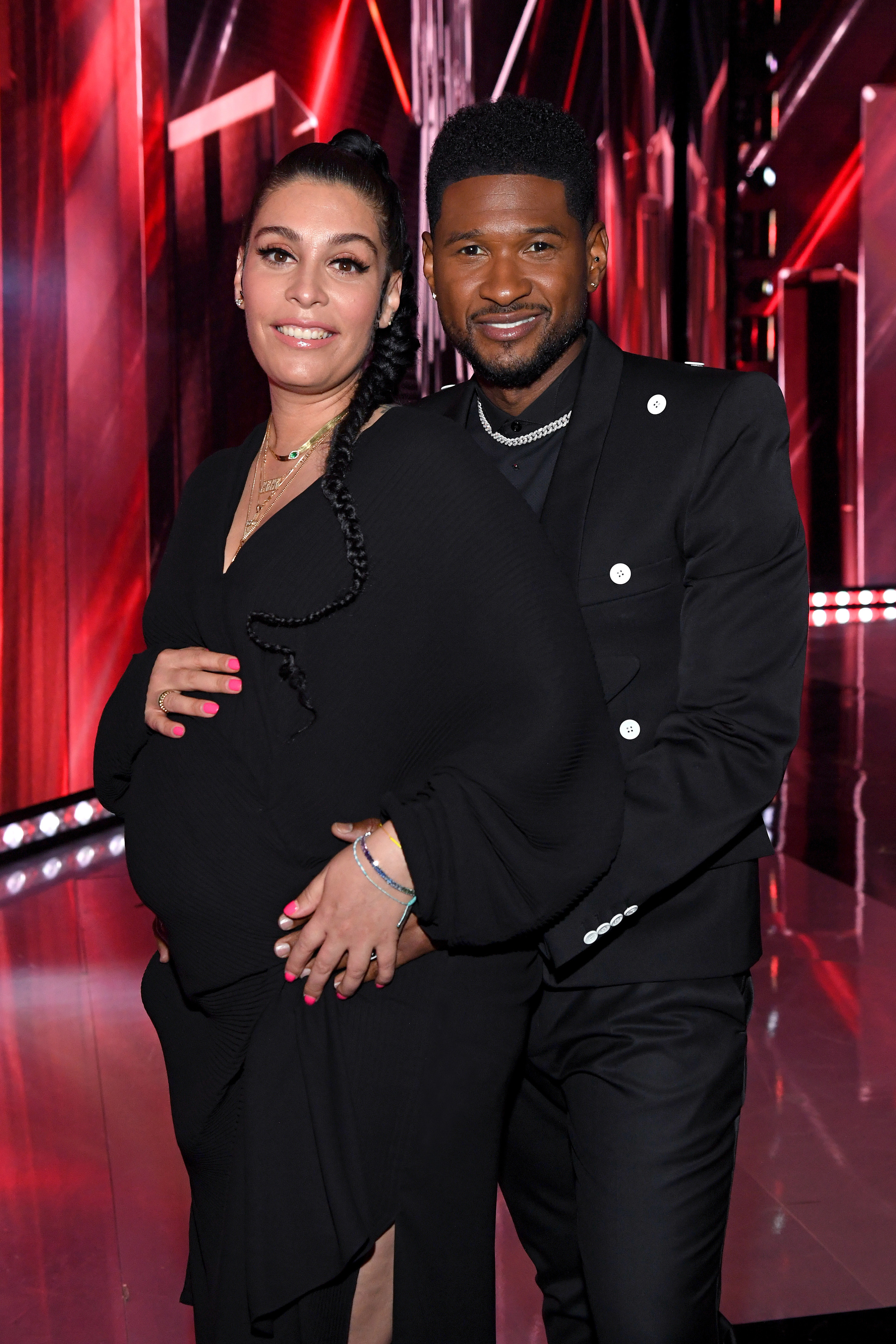 usher and his pregnant girlfriend cradling her pregnant belly