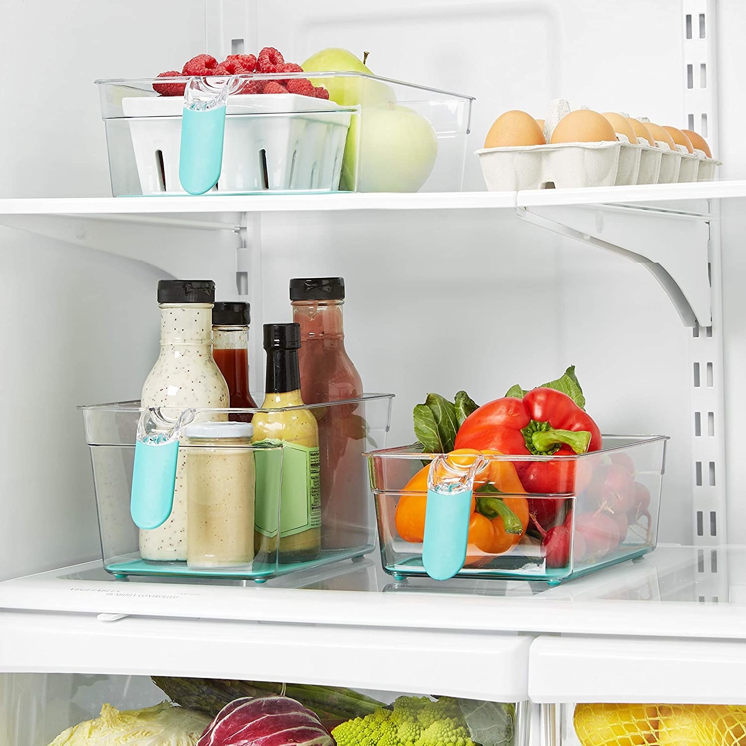 A fridge with three bins full of food inside