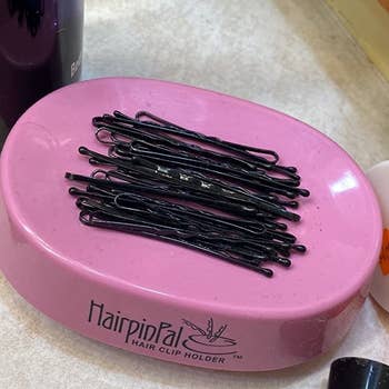 a set of bobby pins sitting in a pink container that looks similar to a plastic soap dish