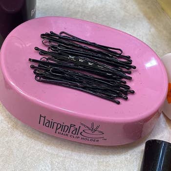 a set of bobby pins sitting in a pink container that looks similar to a plastic soap dish