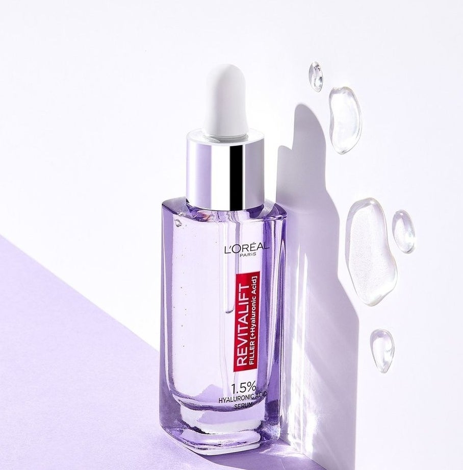 A bottle of serum on a plain background