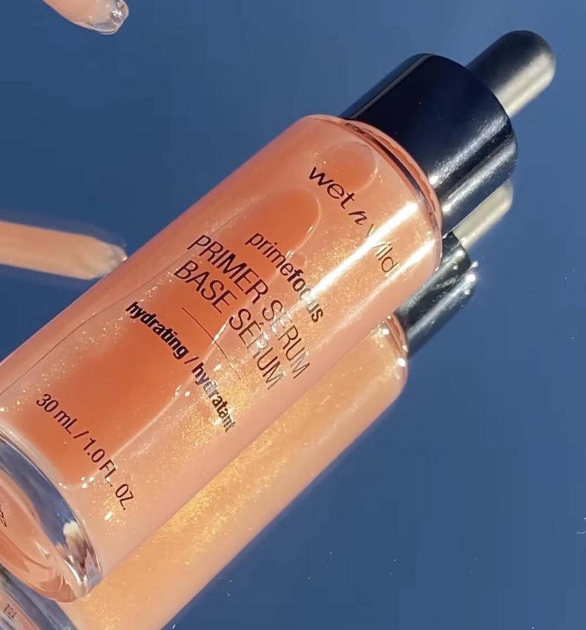 The bottle of primer serum resting on a mirror