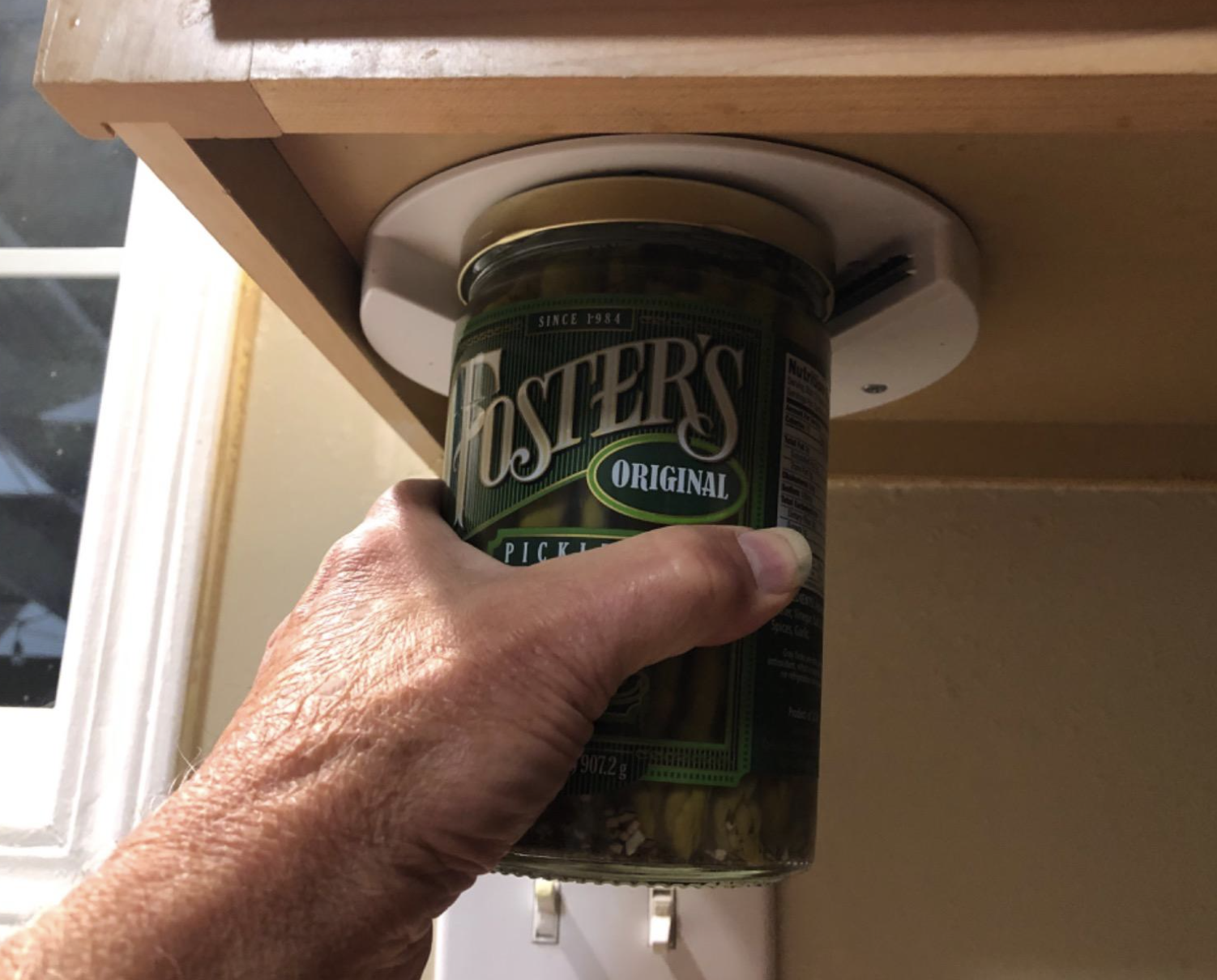 A customer review photo of them opening a jar under their cabinet