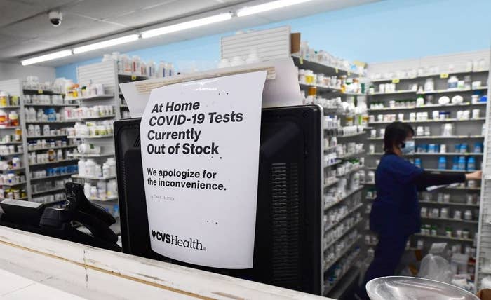 A sign saying COVID tests are out of stock on the window of a CVS pharmacy