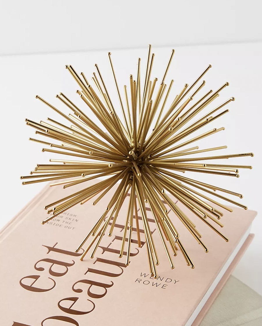 the burst decorative object in gold sitting on a book