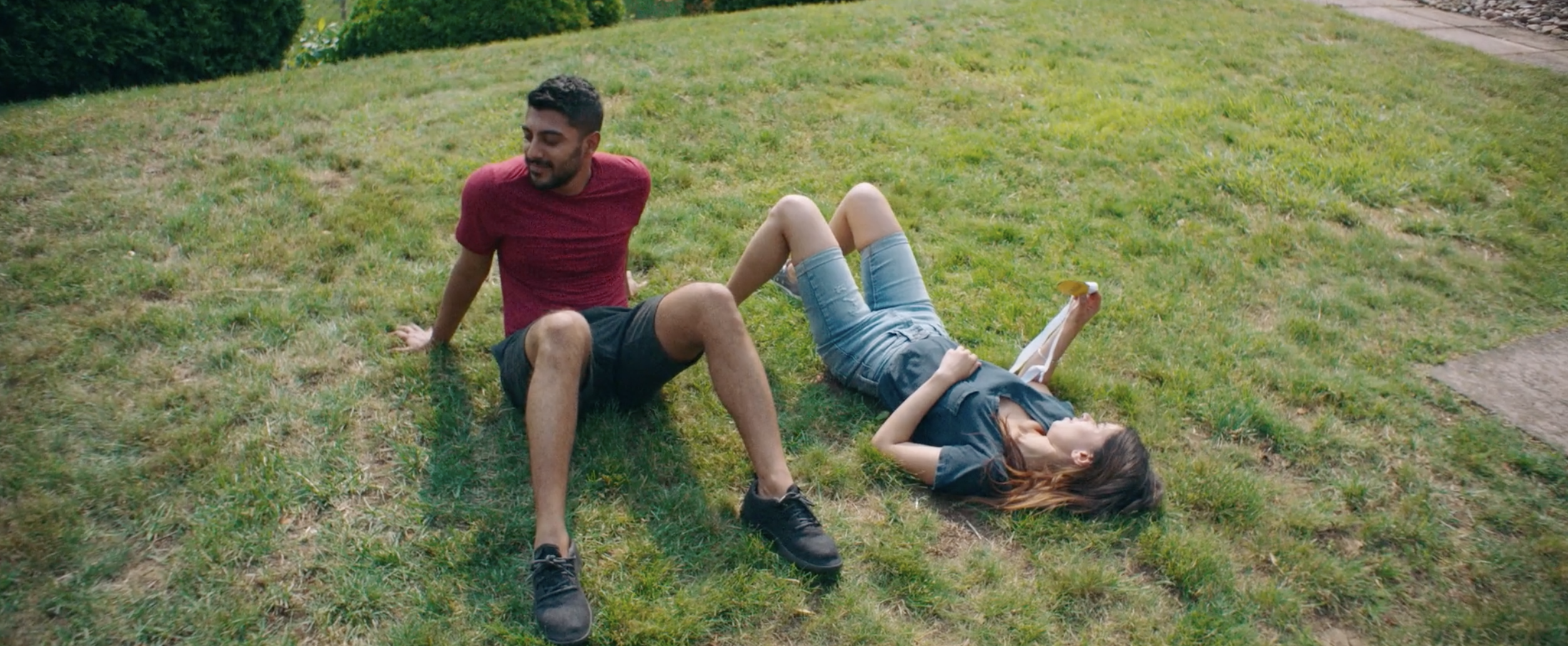 Monica and Sonny laying in grass outside