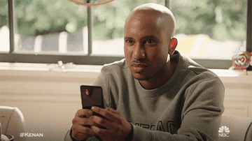 Chris Redd as Gary Williams glares upwards as he continues to type on his cell phone in &quot;Kenan&quot;