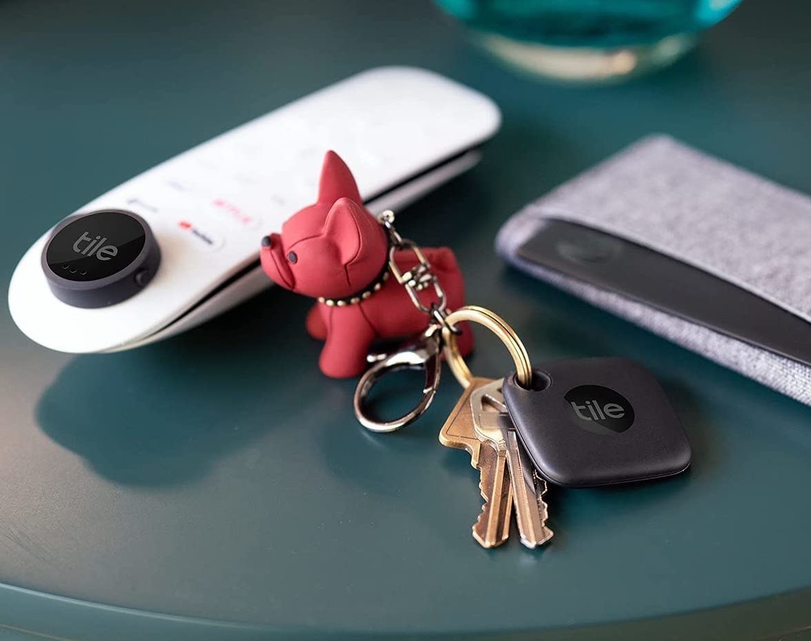 A Tile mate tracker on a keychain with keys, a remote, and in a wallet
