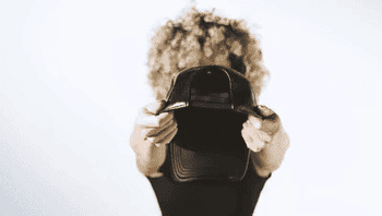 GIF of the founder demonstrating how the hat's elastic makes for a comfortable fit over their hair