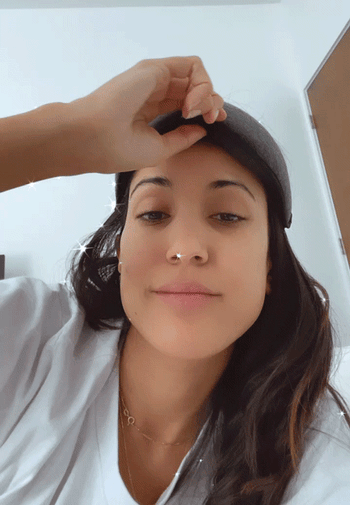 GIF of Jasmin in a sun-filled room putting the mask on
