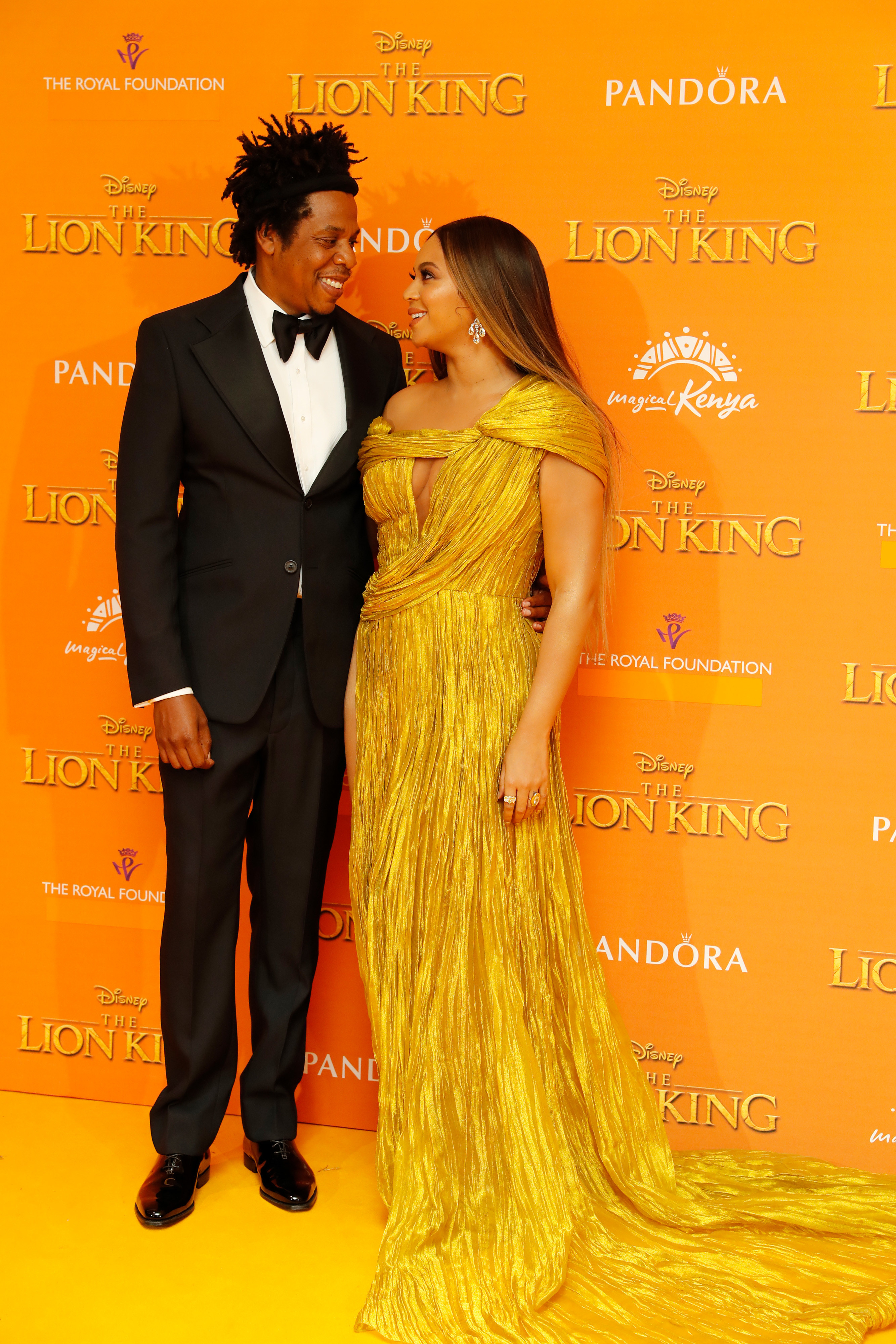 Beyonce in a gold dress and Jay-Z in a black suit at the Lion King premiere