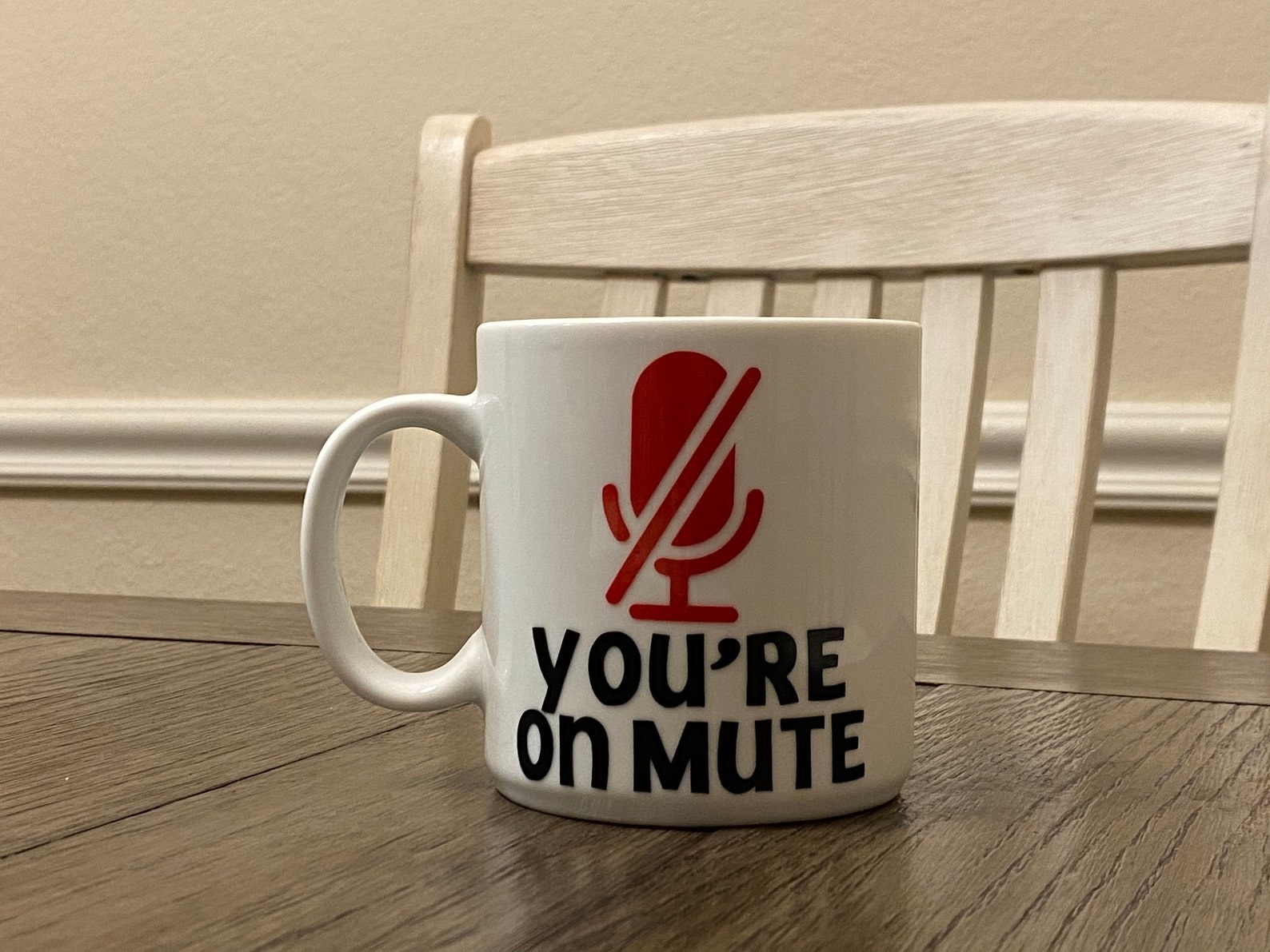 The white mug with a red mute mic symbol and the words you&#x27;re on mute