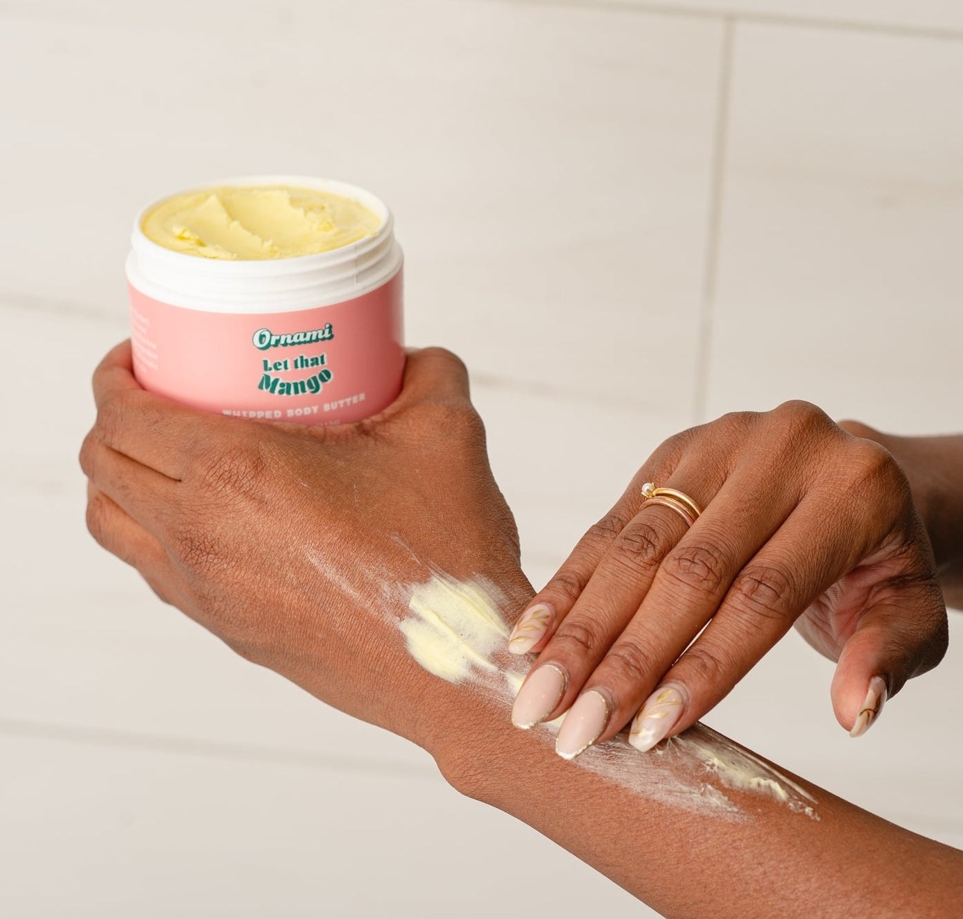 model applying the body butter to their arm